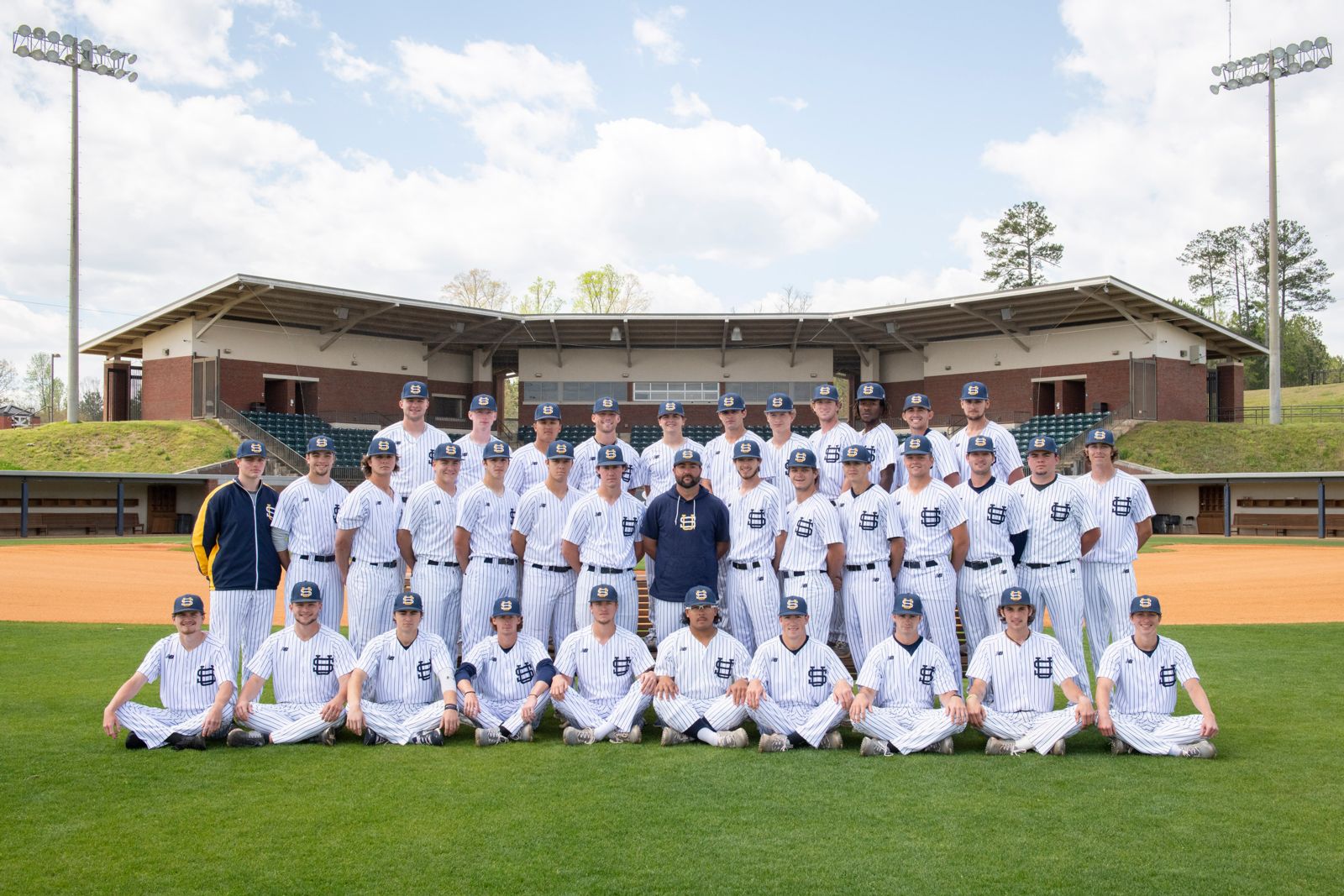 suscc baseball team posing for a photograph as a team on a baseball field