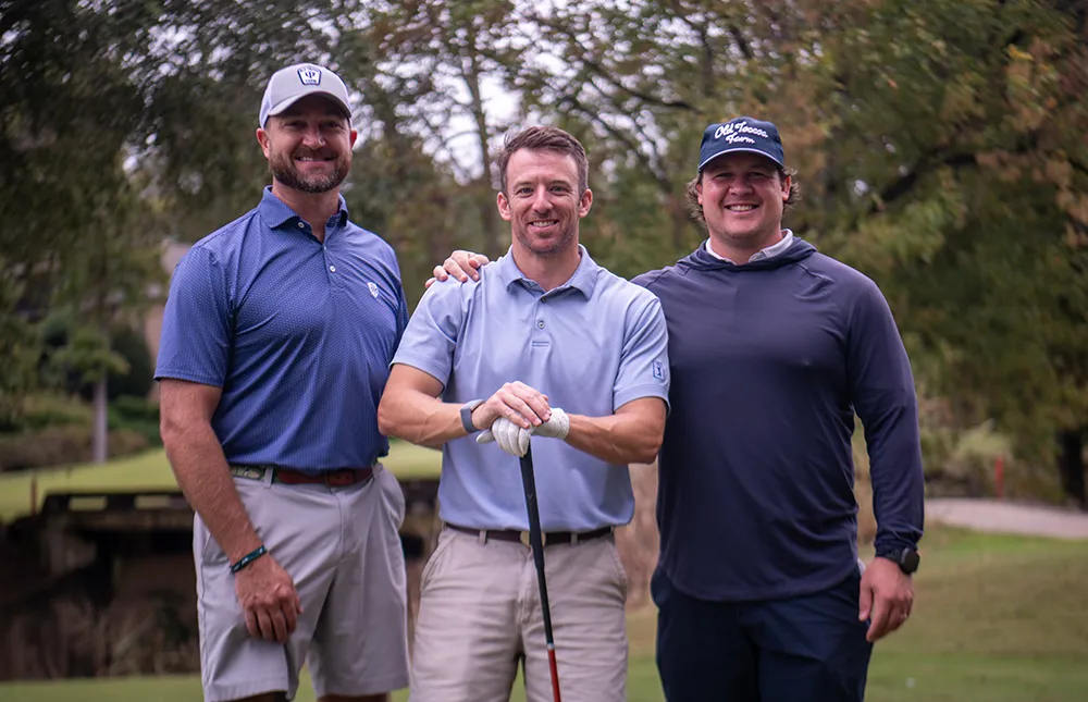 Three gentlemen posing with golf equipment