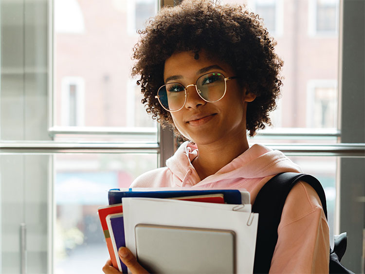 Student with books smiling